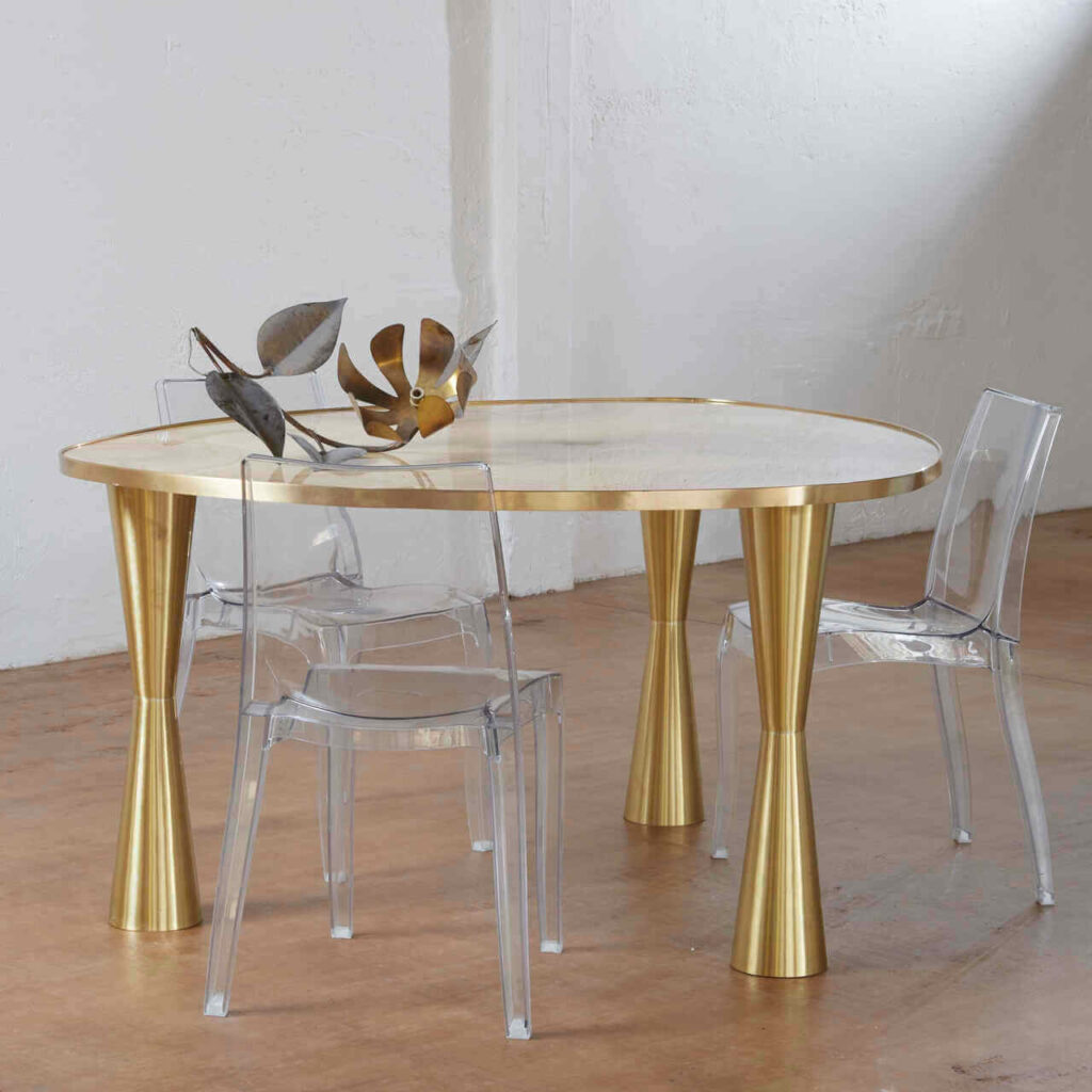 View of the table illuminated by natural light, enhancing the golden tones of the onyx and the sheen of the brass.